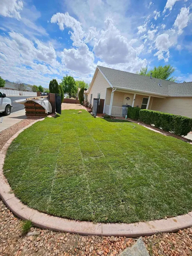 Freshly installed sod lawn with curved concrete mow curb border at a home in Washington County, Utah
